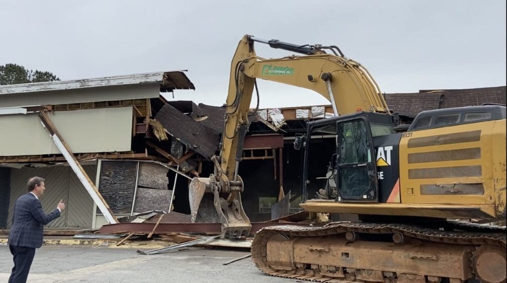 Man in suit next to front end loader