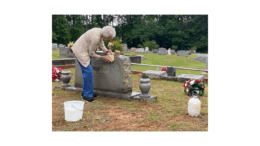 A woman cleans a headstone