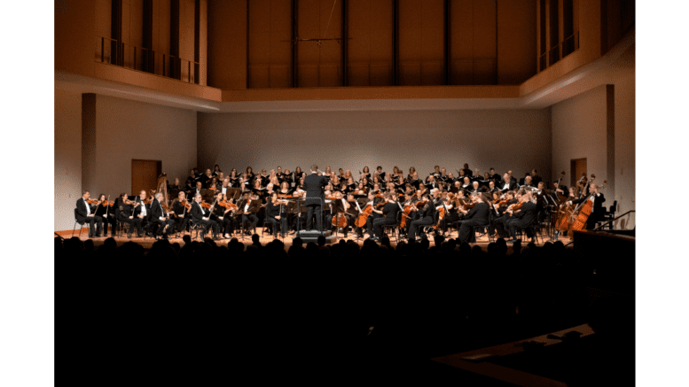 Georgia Symphony Music Director and Conductor Timothy Verville (standing, foreground) will lead the orchestra’s May 21, 2022, season finale performance at KSU’s Bailey Performance Center.