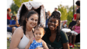 Two adult women and a baby, women smiling toward camera