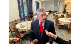 Georgia Secretary of State Brad Raffensperger in suit at press conference with microphone toward face