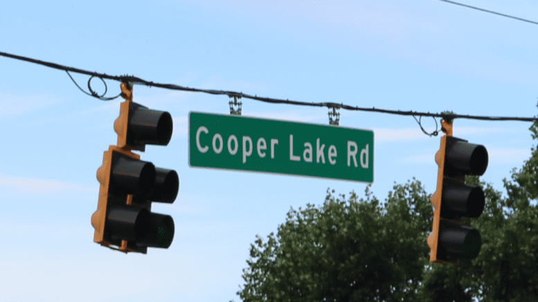 Cooper Lake Road sign flanked by two traffic lights