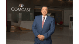 Jeff Buzzelli in suit in front of Comcast sign