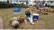 A scarecrow in a lounge chair surrounded by pumpkins