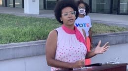 Brionté McCorkle speaking outdoors at a podium