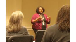 Latonia Hines standing, speaking to seated residents