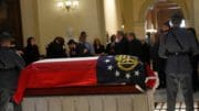 Georgia State Troopers stand guard over Speaker David Ralston’s flag-draped casket as loved ones and lawmakers share hugs and condolences. Ross Williams/Georgia Recorder