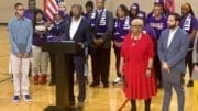 Sen. Raphael Warnock surrounded by supporters at a microphone