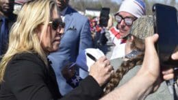 Congresswoman Marjorie Taylor Greene signed a supporter’s shirt at a March rally for former President Donald Trump. Ross Williams/Georgia Recorder