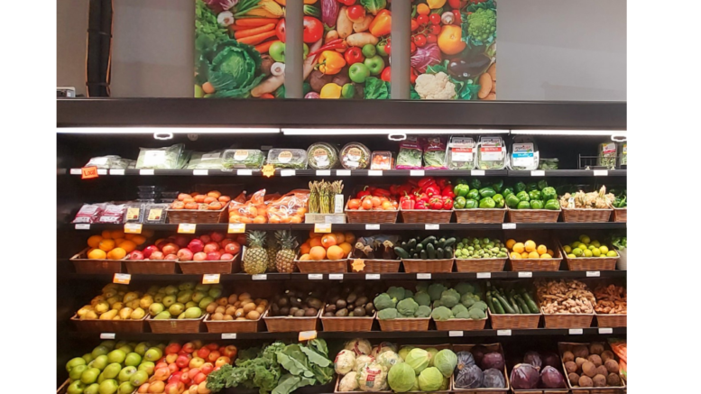 Rows of shelves with colorful vegetables in small brown bins