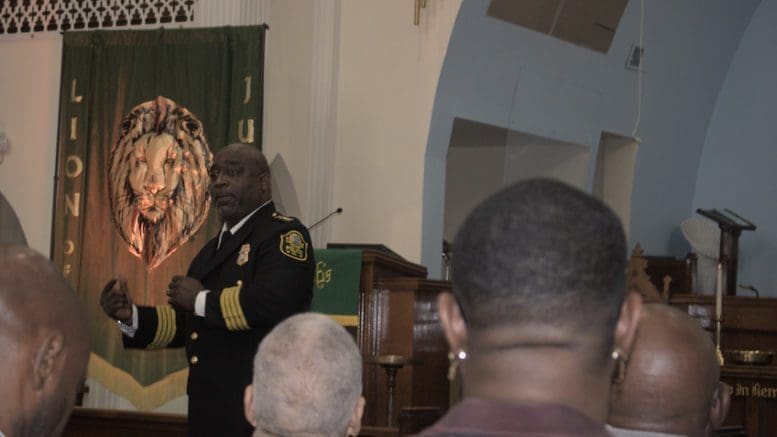 Austell police Chief Scott Hamilton speaks before a crowd in Austell First United Methodist Church sanctuary