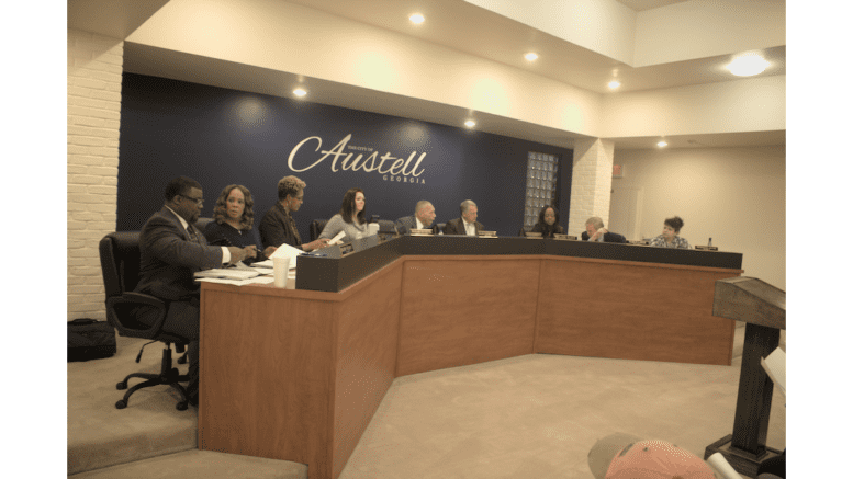 The six city council members, Mayor, city clerk, and city attorney for Austell, all seated at the desk in council chambers