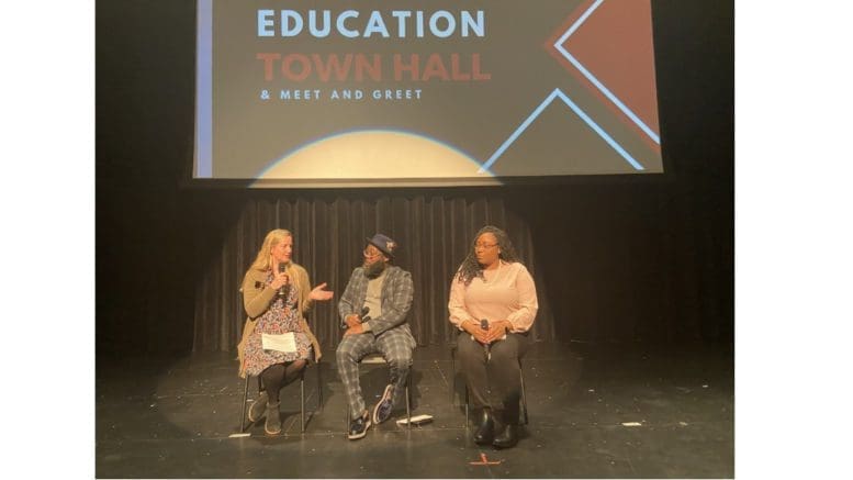 Democratic school board members Becky Sayler, Leroy Tre’ Hutchins, and Nichelle Davis onstage at a town hall at South Cobb High School.