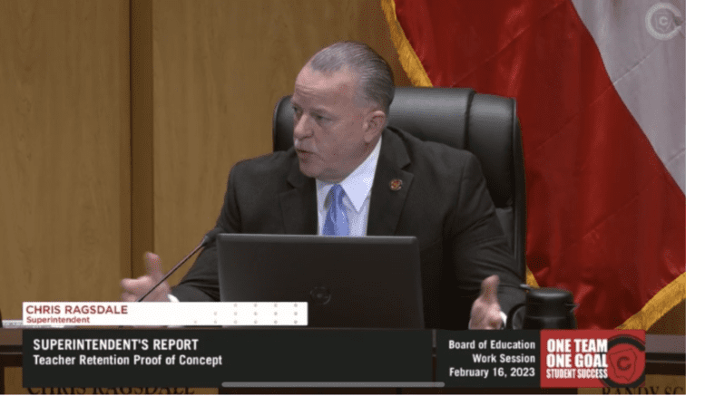 A screenshot of Cobb school superintendent Chris Ragsdale seated at a podium talking