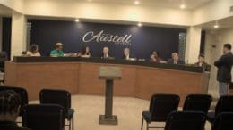 The six members of the Austell City Council plus two staffers seated on the podium before the meeting begins