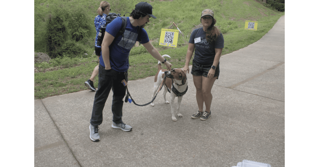 A man and woman with a dog on a leash between them on the Silver Comet Trail