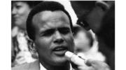 Black and White photo of Harry Belafonte with a microphone in front, at the 1963 March on Washington