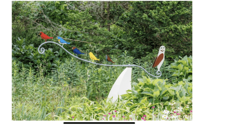 a statue of a row of colorful birds perched on a stylized metal branch