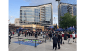 A crowd of people at The Battery Atlanta, buildings with glass windows in background