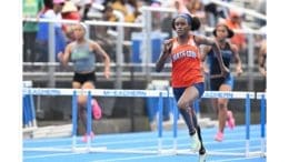 Young woman running in high school track event