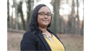 Laura Judge outdoors wearing a yellow shirt and dark jacket