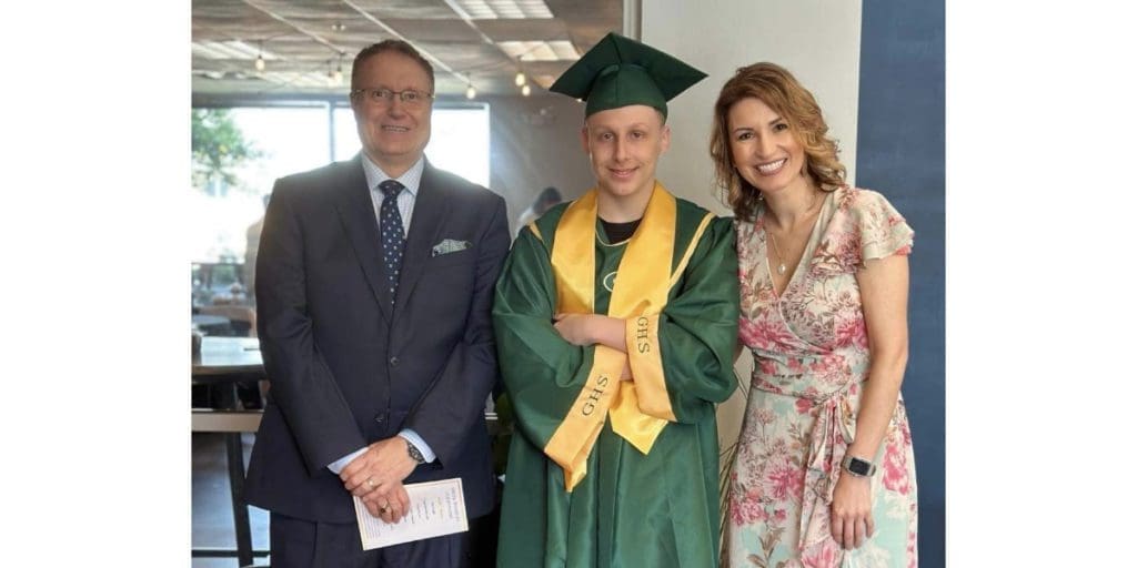 Juvenile court Judge Wayne Grannis and family law attorney Dena Crim pose with graduate Frank.