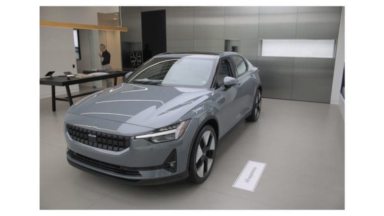 A gray electric vehicle in a small showroom