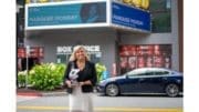 Stacey Chapman holding trophy in front of a theatre marquee