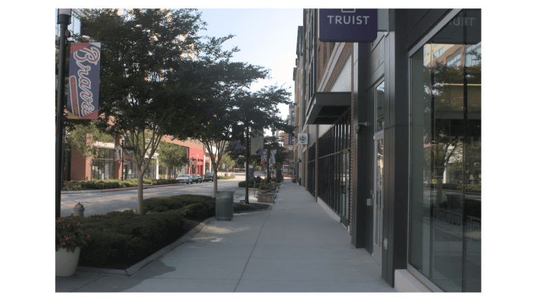 A sidewalk lined with storefronts in The Battery