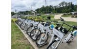 A row of identical bicycle s locked onto station