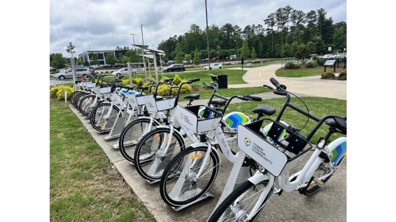 A row of identical bicycle s locked onto station