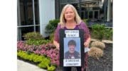 Beverly Wynne holding sign with photo of her son and words, "my son is not a divisive concept"