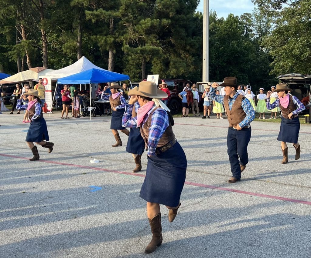 Dancers in cowboy hats, five women one man