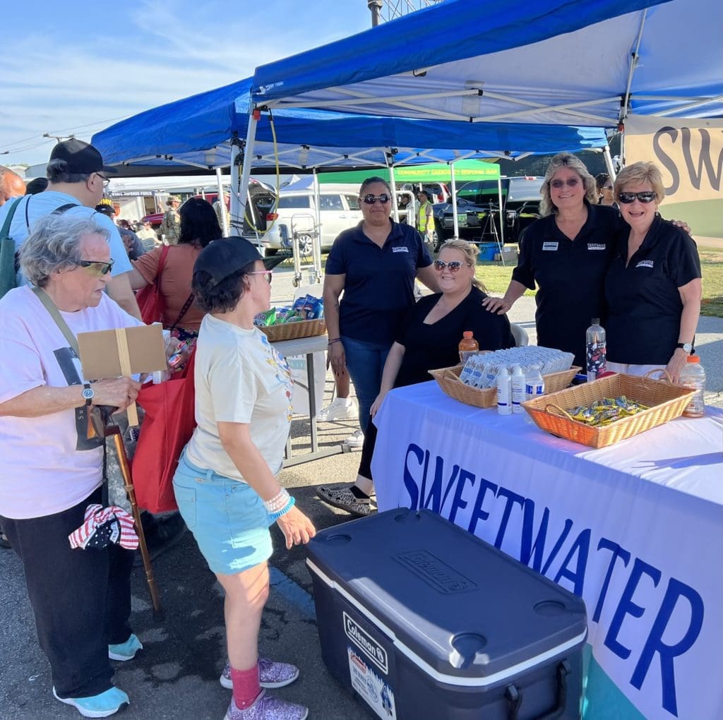 A group of people, mostly women, at a Sweetwater Mission table