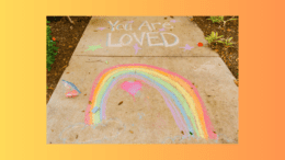 A sidewalk with a chalk rainbow and the words "You are loved"