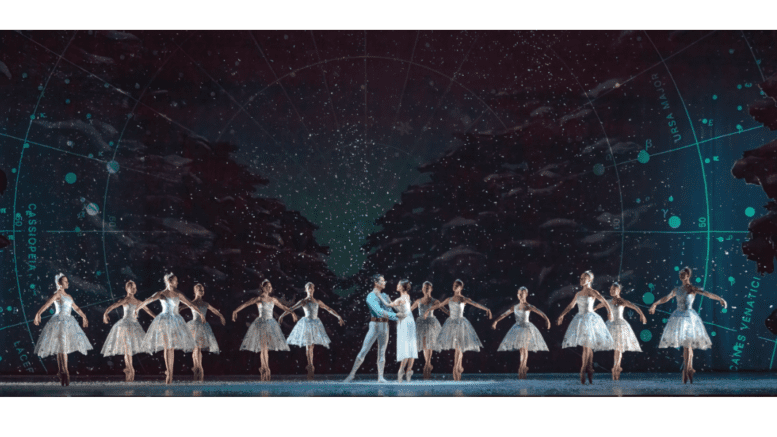 A long row of ballet dancers with a man and woman at the center