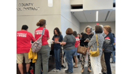 A group of people milling around the lobby during signup for public comment at the Cobb County School District