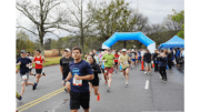 A large group of runners in a race, coming off the starting line