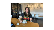 Jennifer Susko seated at a table wearing a "Teach Black History" t-shirt