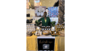 A woman sits at an exhibit stall in a market