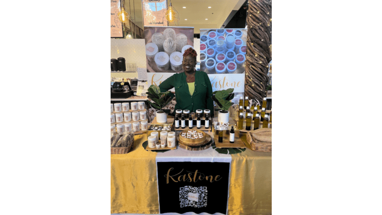 A woman sits at an exhibit stall in a market