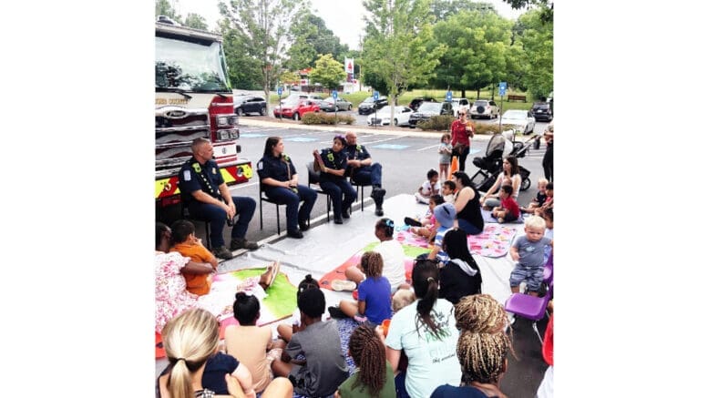 A group of firefighters in front of a seated group