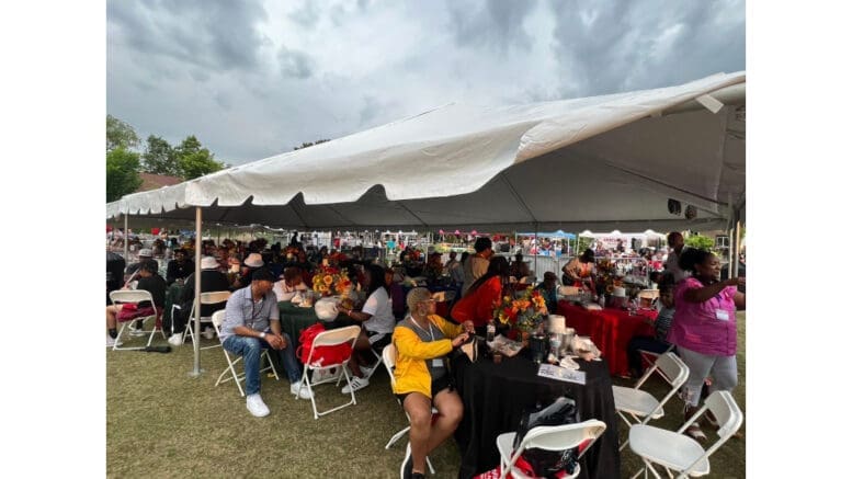 A crowd of people enjoying food under a tent