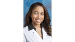 Headshot of Dr. Dorie Saxon, wearing a doctor's jacket, smiling