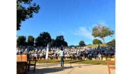 A woman speaks to a large crowd of volunteers