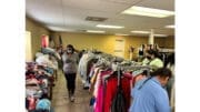 People examining racks of clothing at a charitable distribution