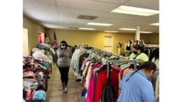 People examining racks of clothing at a charitable distribution