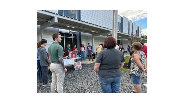 A group of people in vigil outside the Cobb County School District offices