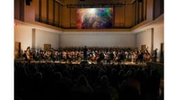 The Georgia Smyphony Orchestra in performance with a projection screen overhead