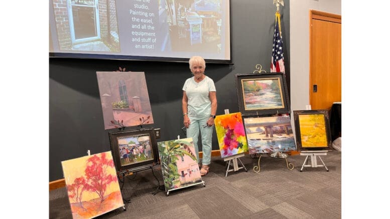 Marsha Hamby Savage surrounded by her art works